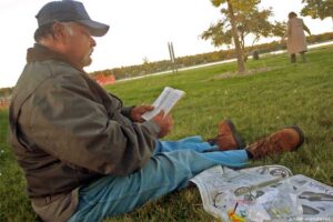 A homeless vet reads a book in Sloan's Lake park in Denver