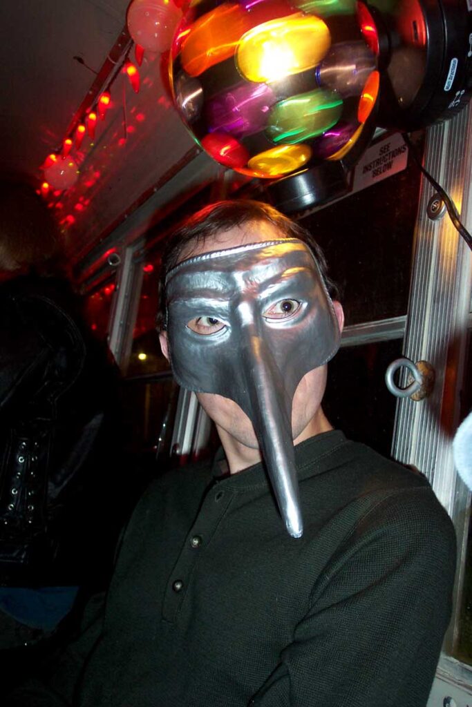 An artbus rider in a Venetian Mardi Gras mask
